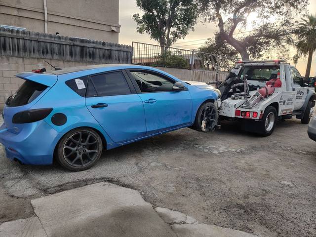 Budget Towing truck hooking up a Mazda 3 hatchback
